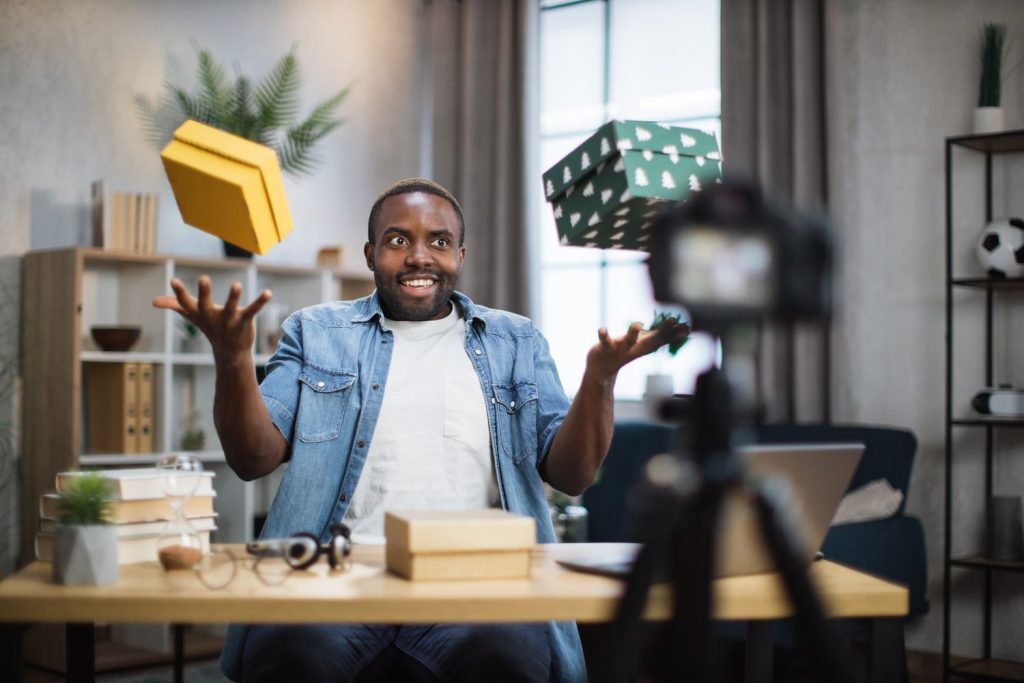 man recording video blog while unpacking presents 5K93SJV